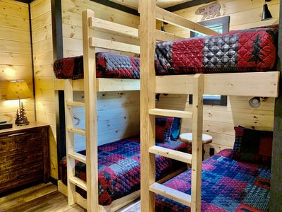 A room with two wooden double-decker beds